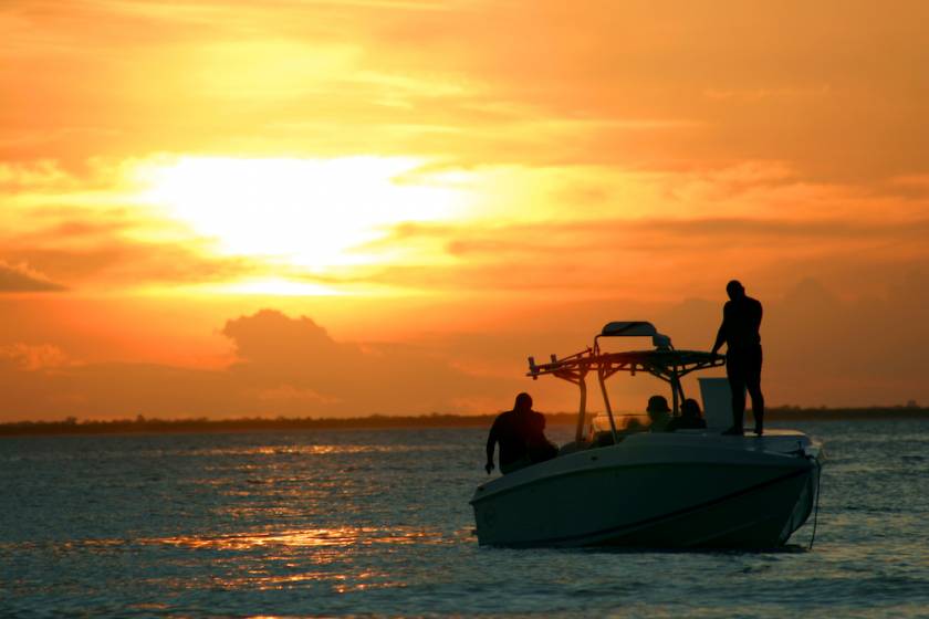 people on a fishing boat at sunset
